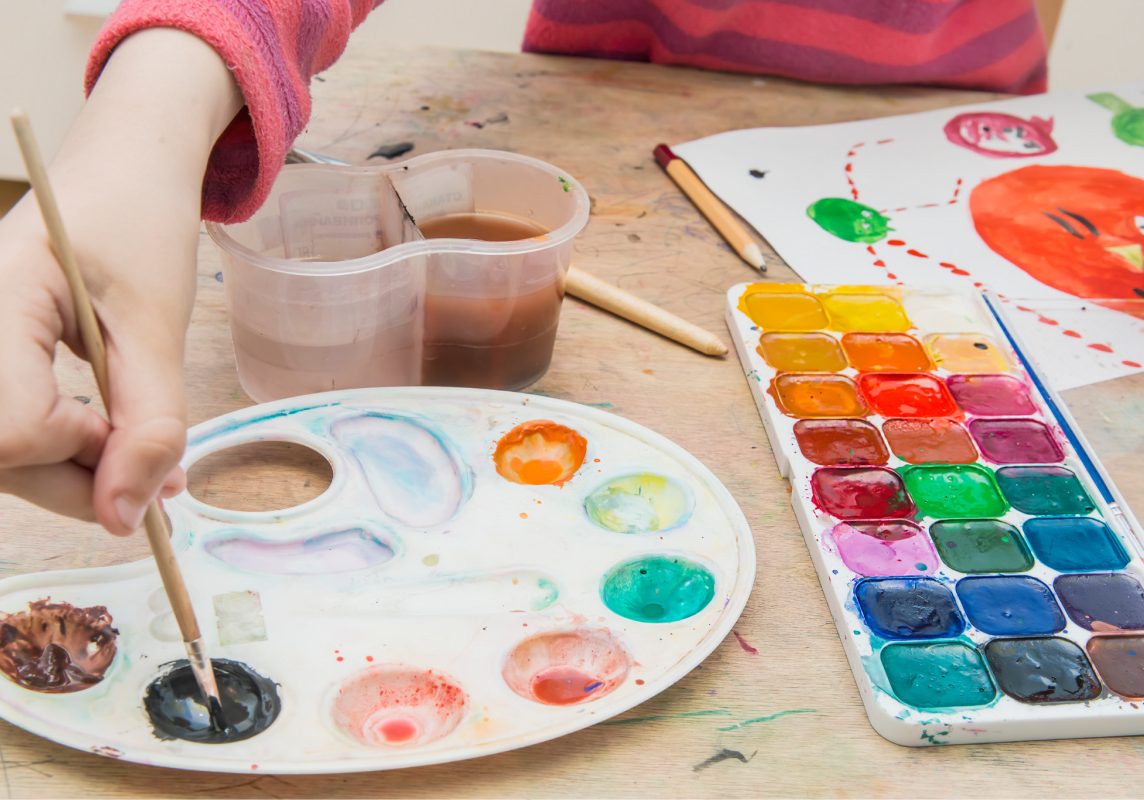 The little girl painting on a desk